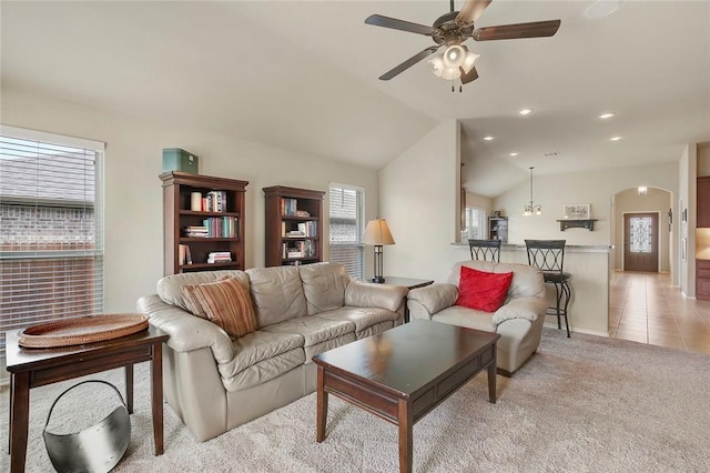 carpeted living room with lofted ceiling and ceiling fan