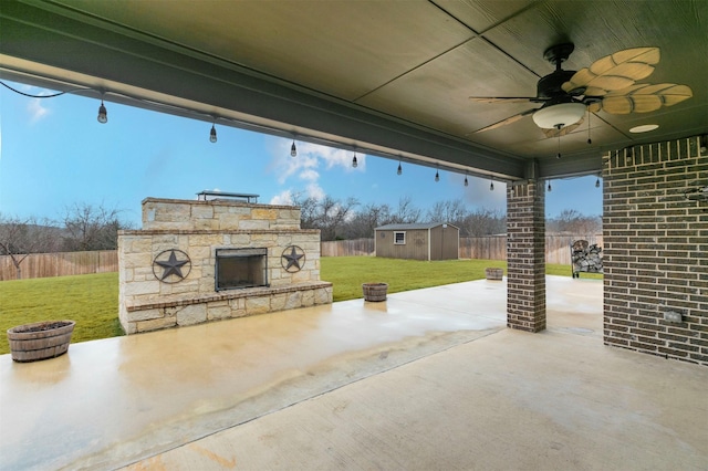 view of patio with an outdoor stone fireplace, ceiling fan, and a storage shed