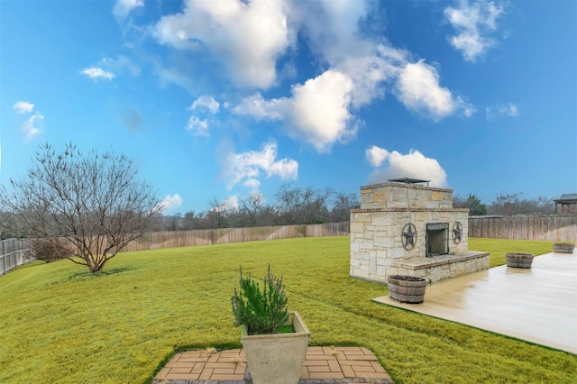 view of yard featuring a patio area and an outdoor stone fireplace