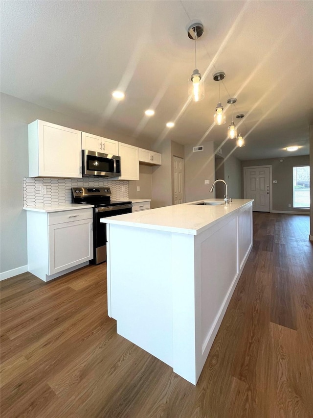 kitchen featuring sink, white cabinetry, a center island with sink, appliances with stainless steel finishes, and pendant lighting