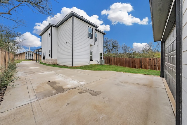 view of home's exterior featuring central AC, a patio, and a lawn