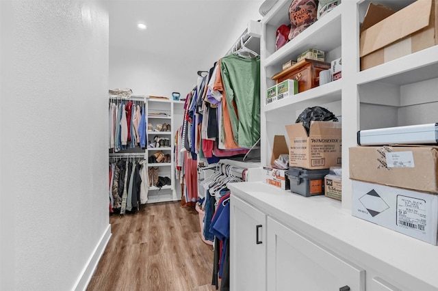 walk in closet with light hardwood / wood-style floors