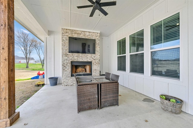 view of patio with ceiling fan and a fireplace