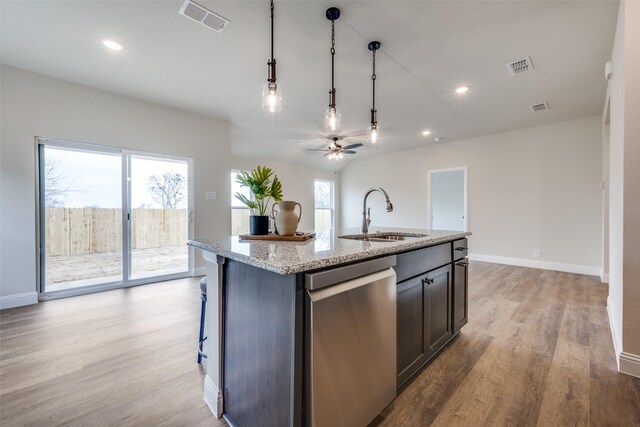 102 Walnut St, Whitesboro, TX 76273 - kitchen with a sink, dishwasher, light wood-style flooring, a center island with sink, and hanging light fixtures