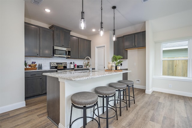 102 Walnut St, Whitesboro, TX 76273 - kitchen with stainless steel appliances, a sink, tasteful backsplash, light wood-style flooring, and recessed lighting