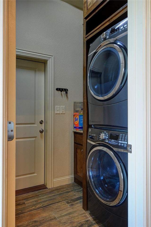 laundry area featuring dark hardwood / wood-style floors and stacked washing maching and dryer