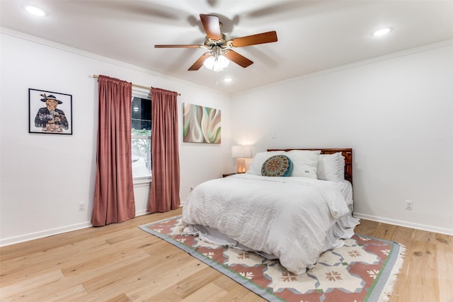 bedroom with baseboards, crown molding, and light wood finished floors