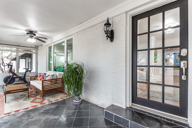 exterior space with ceiling fan and brick siding