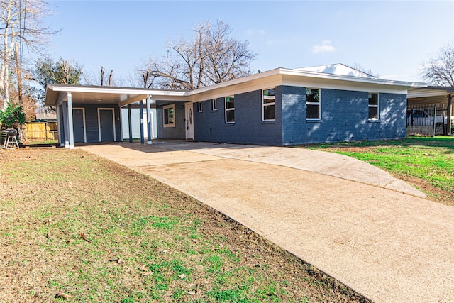 view of front of property featuring a carport, brick siding, concrete driveway, and fence