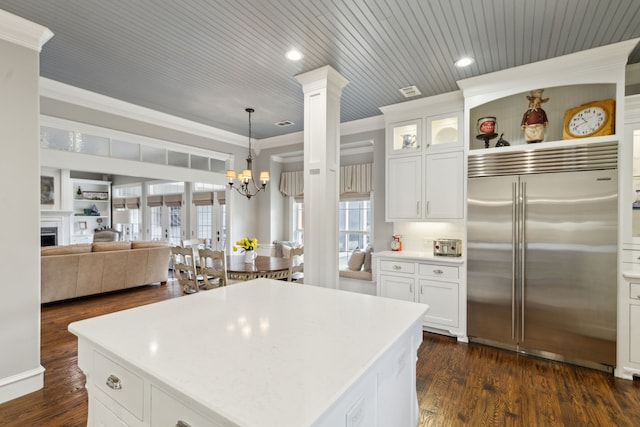 kitchen with dark hardwood / wood-style floors, white cabinetry, hanging light fixtures, ornamental molding, and stainless steel built in fridge