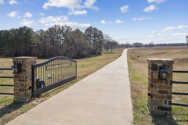 view of gate featuring a rural view and a yard