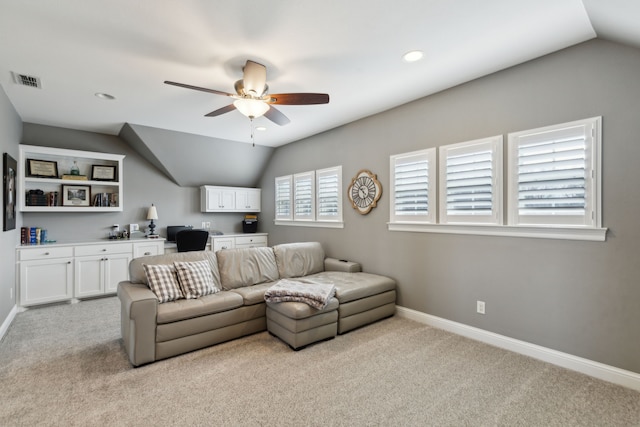 carpeted living room featuring vaulted ceiling, built in desk, and ceiling fan