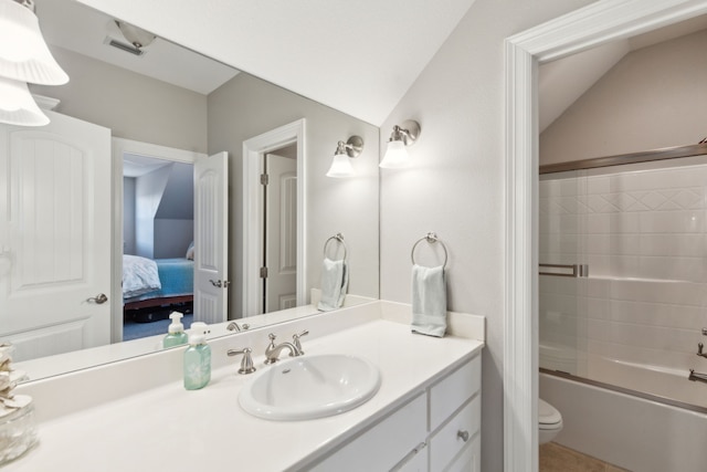 full bathroom featuring vaulted ceiling, vanity, toilet, and combined bath / shower with glass door