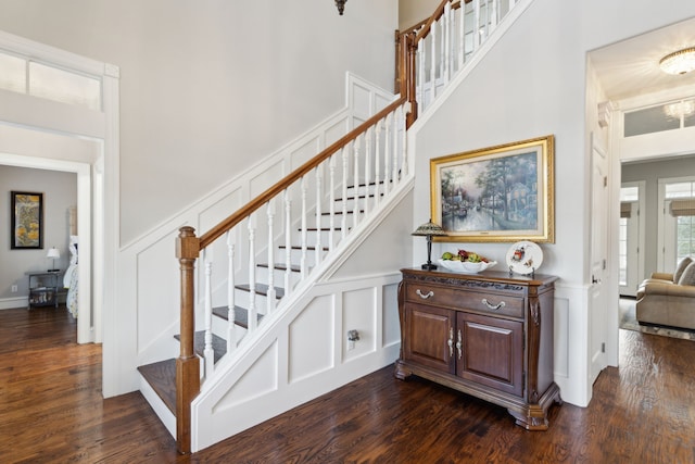 staircase with hardwood / wood-style flooring and a high ceiling