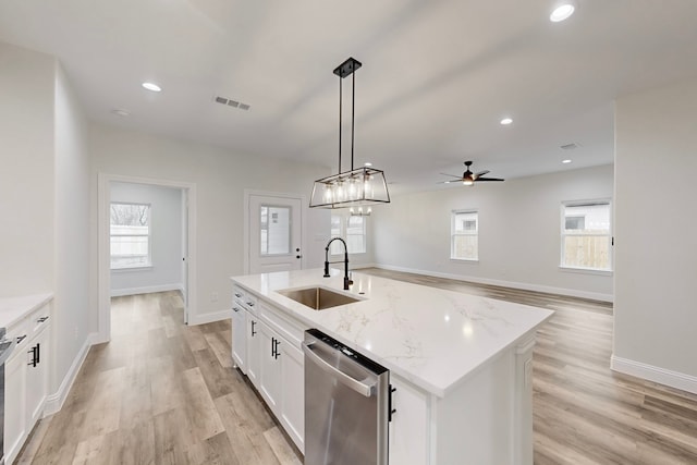 kitchen with sink, white cabinetry, hanging light fixtures, dishwasher, and a kitchen island with sink