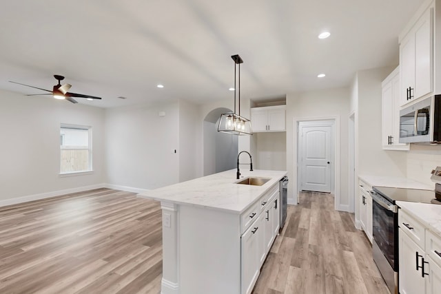 kitchen featuring stainless steel appliances, a kitchen island with sink, sink, and white cabinets