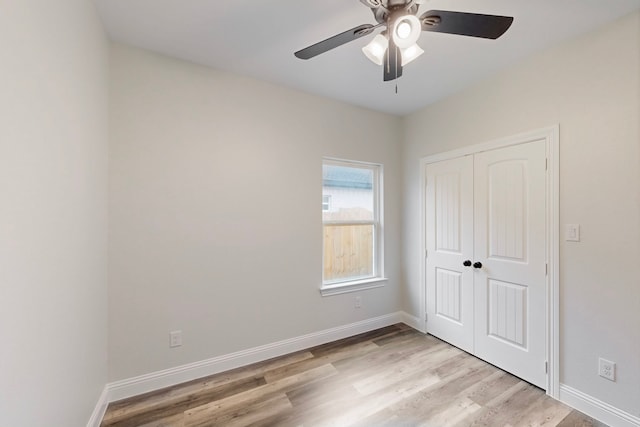 unfurnished bedroom with ceiling fan, light wood-type flooring, and a closet