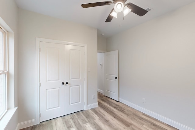 unfurnished bedroom with light hardwood / wood-style flooring, ceiling fan, and a closet