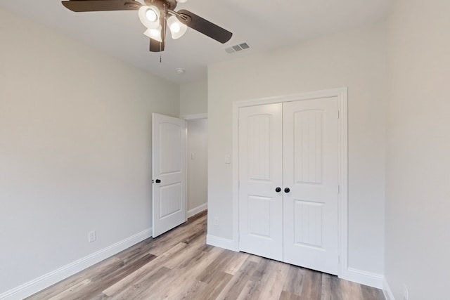 unfurnished bedroom featuring light hardwood / wood-style floors, a closet, and ceiling fan