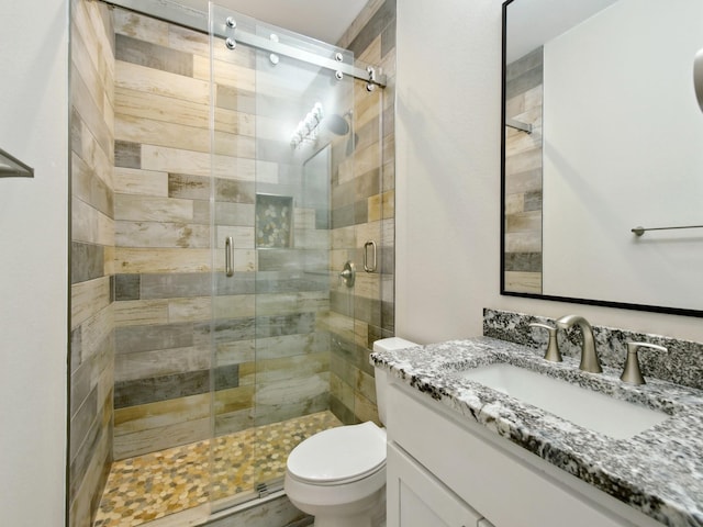 bathroom with vanity, a shower with shower door, and toilet