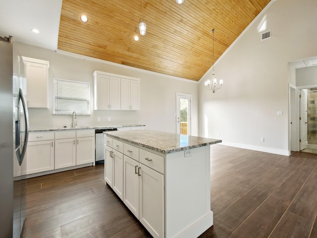 kitchen featuring pendant lighting, stainless steel appliances, white cabinets, and a kitchen island