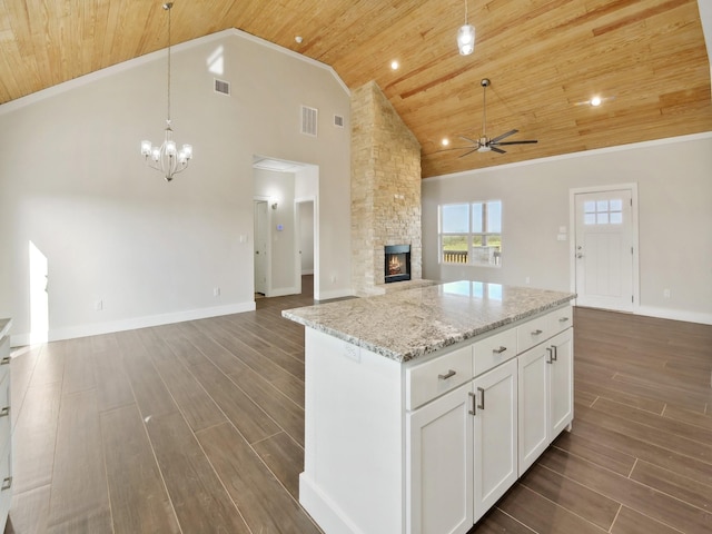 kitchen featuring pendant lighting, light stone countertops, wooden ceiling, and white cabinets