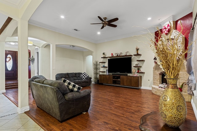 living room featuring wood-type flooring, ornamental molding, and ceiling fan