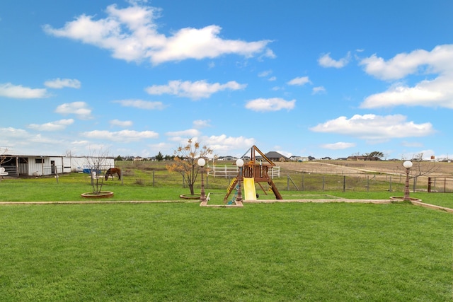 view of playground with a rural view and a lawn