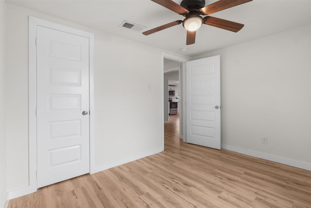 empty room with ceiling fan and light wood-type flooring