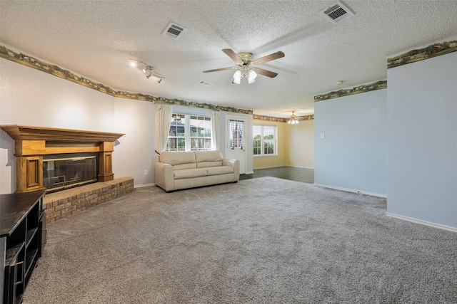 unfurnished living room with a brick fireplace, carpet floors, a textured ceiling, and ceiling fan