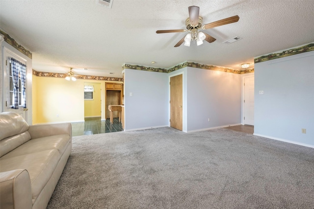 unfurnished living room featuring ceiling fan, carpet, and a textured ceiling