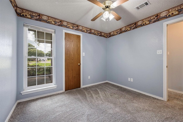 unfurnished room featuring ceiling fan, a textured ceiling, and carpet