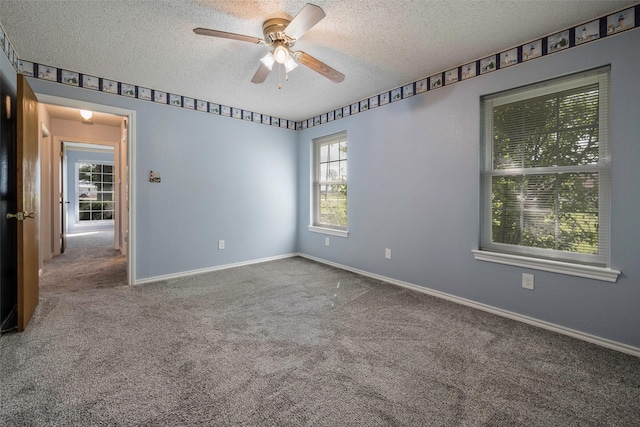 empty room featuring ceiling fan, carpet floors, and a textured ceiling