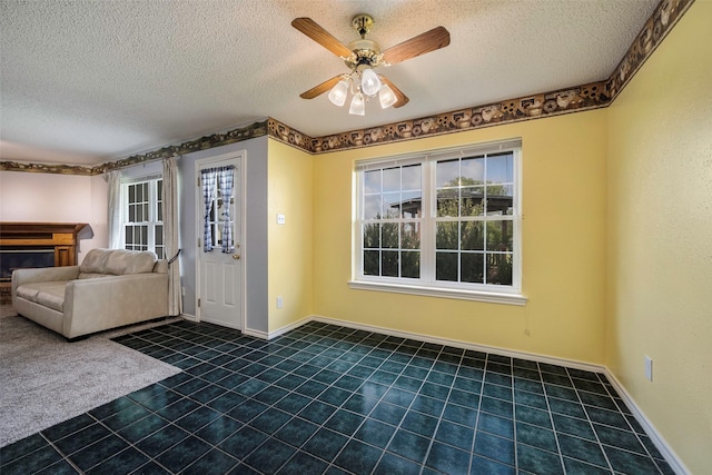 tiled entrance foyer with ceiling fan, plenty of natural light, and a textured ceiling