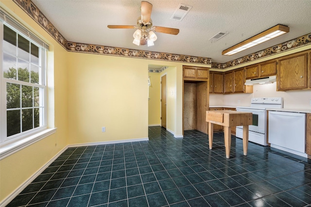 kitchen with ceiling fan, a textured ceiling, white appliances, and dark tile patterned flooring