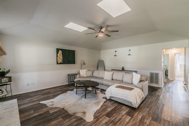 living room with vaulted ceiling with skylight, ceiling fan, and dark hardwood / wood-style floors