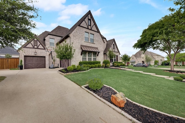 tudor-style house featuring a garage and a front yard