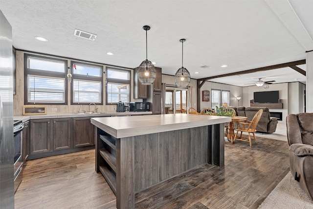 kitchen with a wealth of natural light, stainless steel range with electric cooktop, a center island, and wood-type flooring