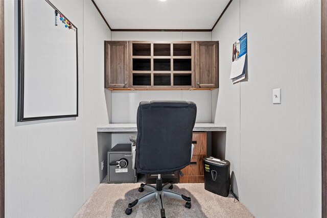 carpeted office featuring crown molding and built in desk