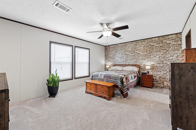 carpeted bedroom featuring ceiling fan, brick wall, and a textured ceiling