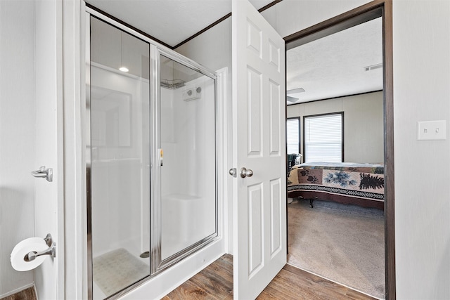 bathroom with walk in shower and wood-type flooring