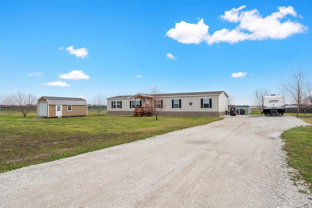 manufactured / mobile home featuring an outdoor structure and a front lawn