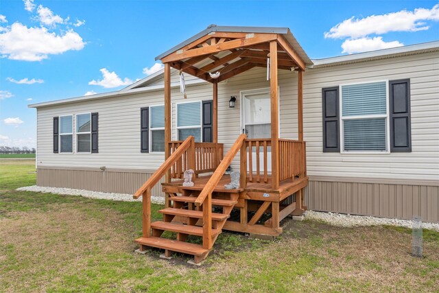 entrance to property with a lawn