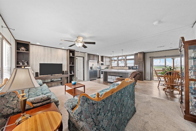 living room featuring ceiling fan and a textured ceiling