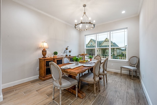 dining space with a notable chandelier, ornamental molding, and light wood-type flooring