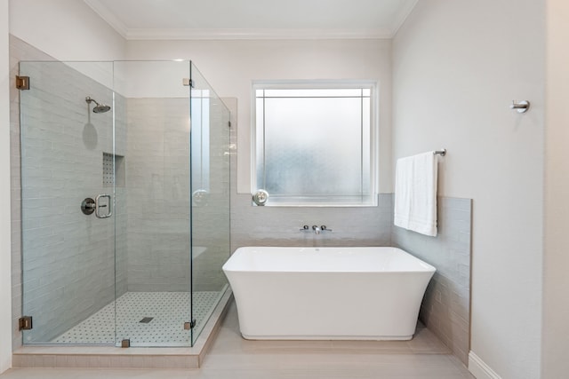 bathroom with crown molding, separate shower and tub, and tile walls