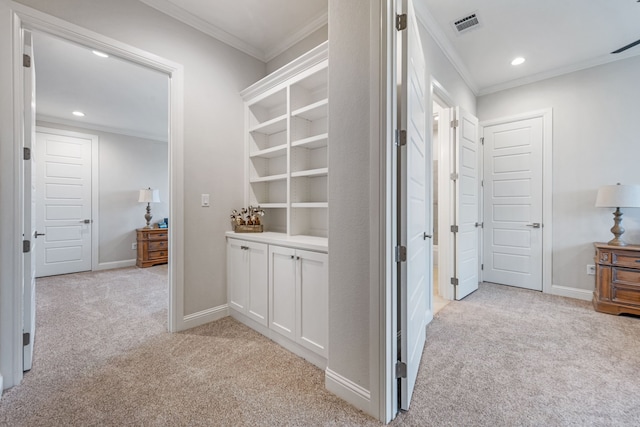 hallway featuring crown molding and light colored carpet