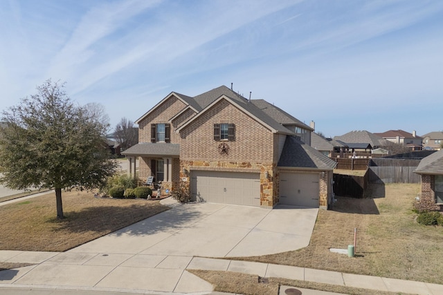 view of front of home featuring concrete driveway, fence, brick siding, and roof with shingles