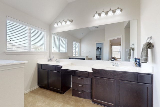 bathroom with vaulted ceiling, tile patterned flooring, and vanity