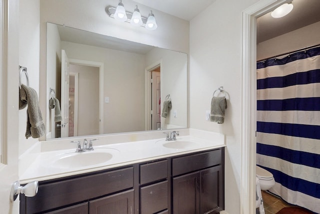 bathroom featuring tile patterned floors, vanity, and toilet